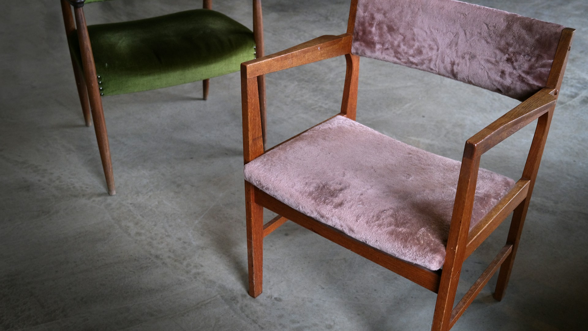 a pair of wooden chairs with pink and green upholstered seats