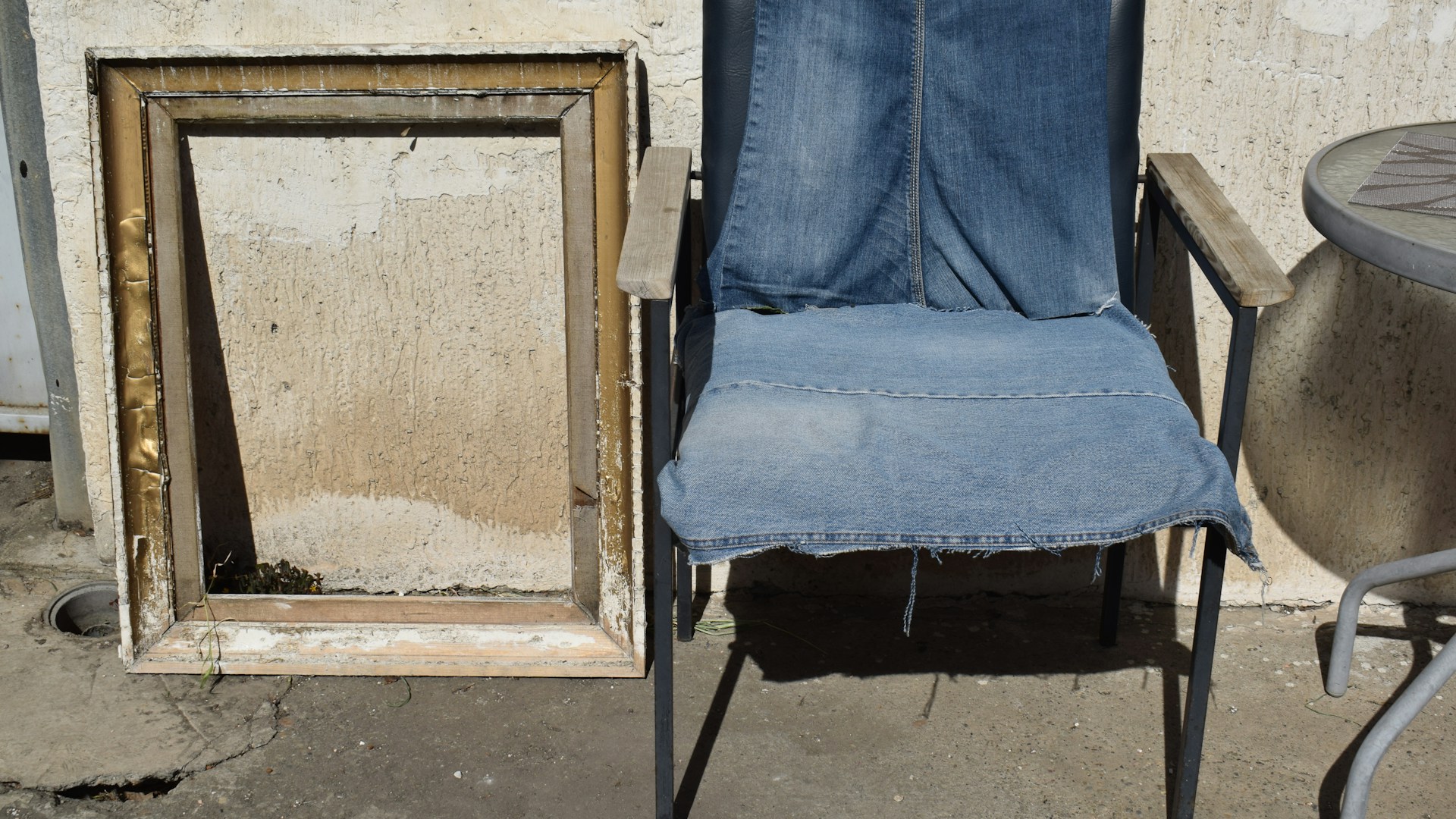 Chair with denim seat next to empty frame