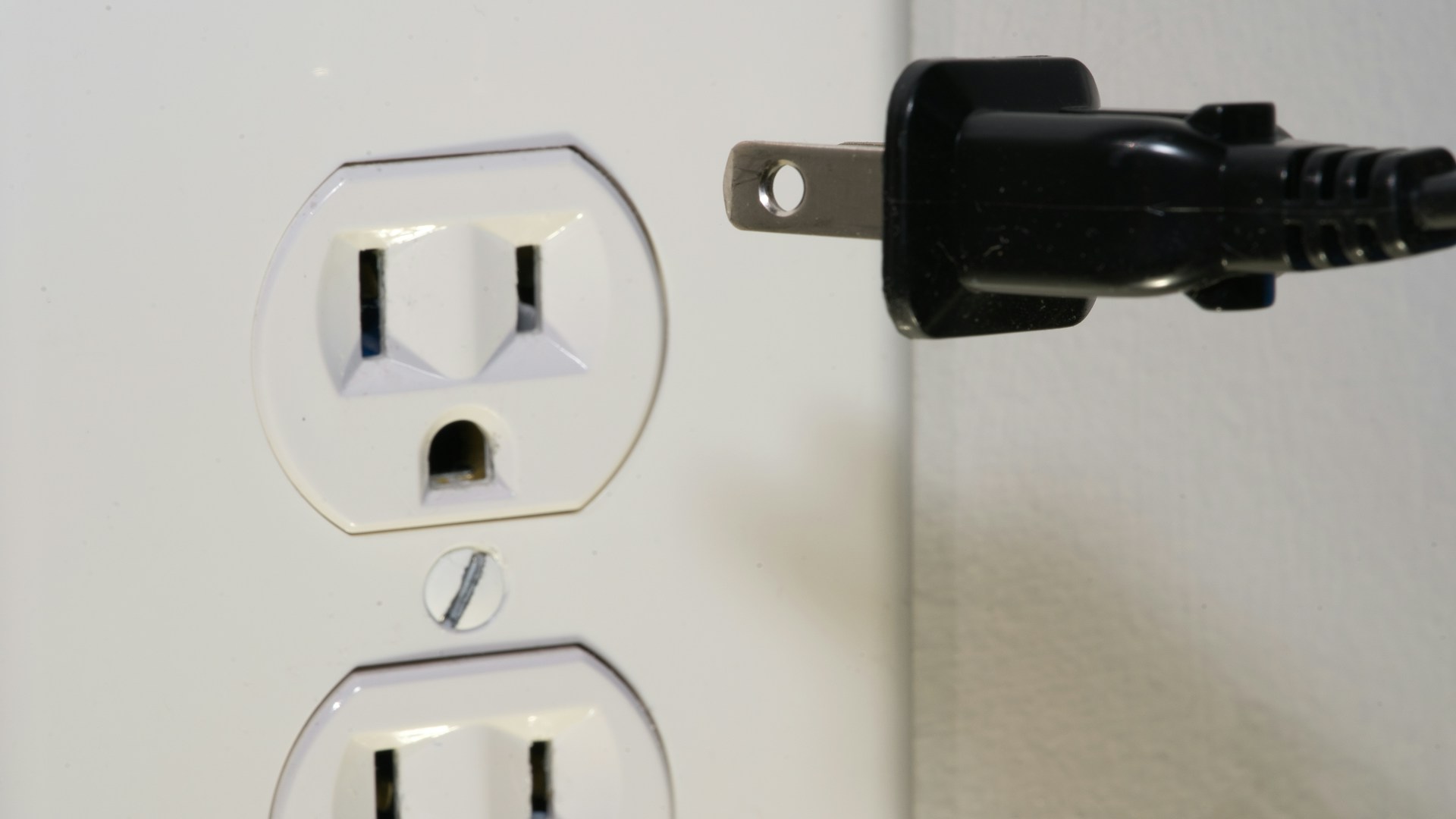 black male plug in front of electric socket