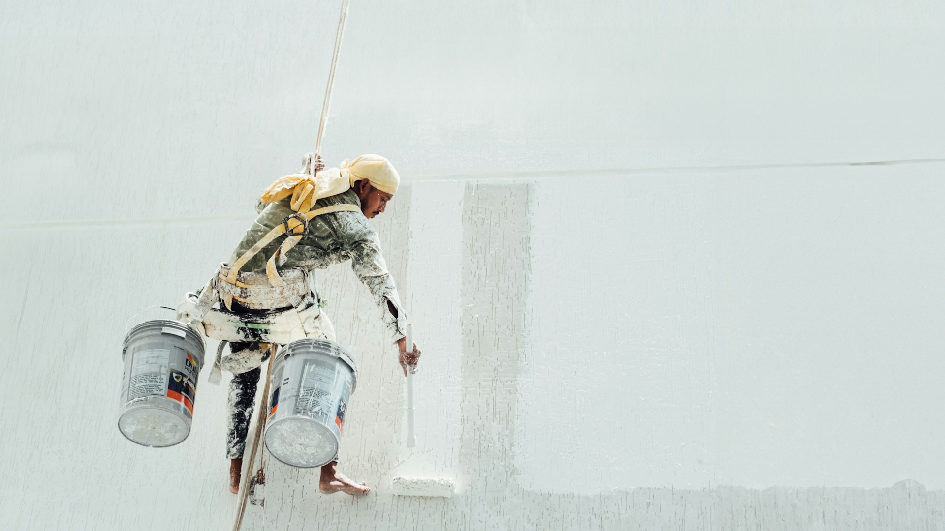 A painter is painting a white wall.