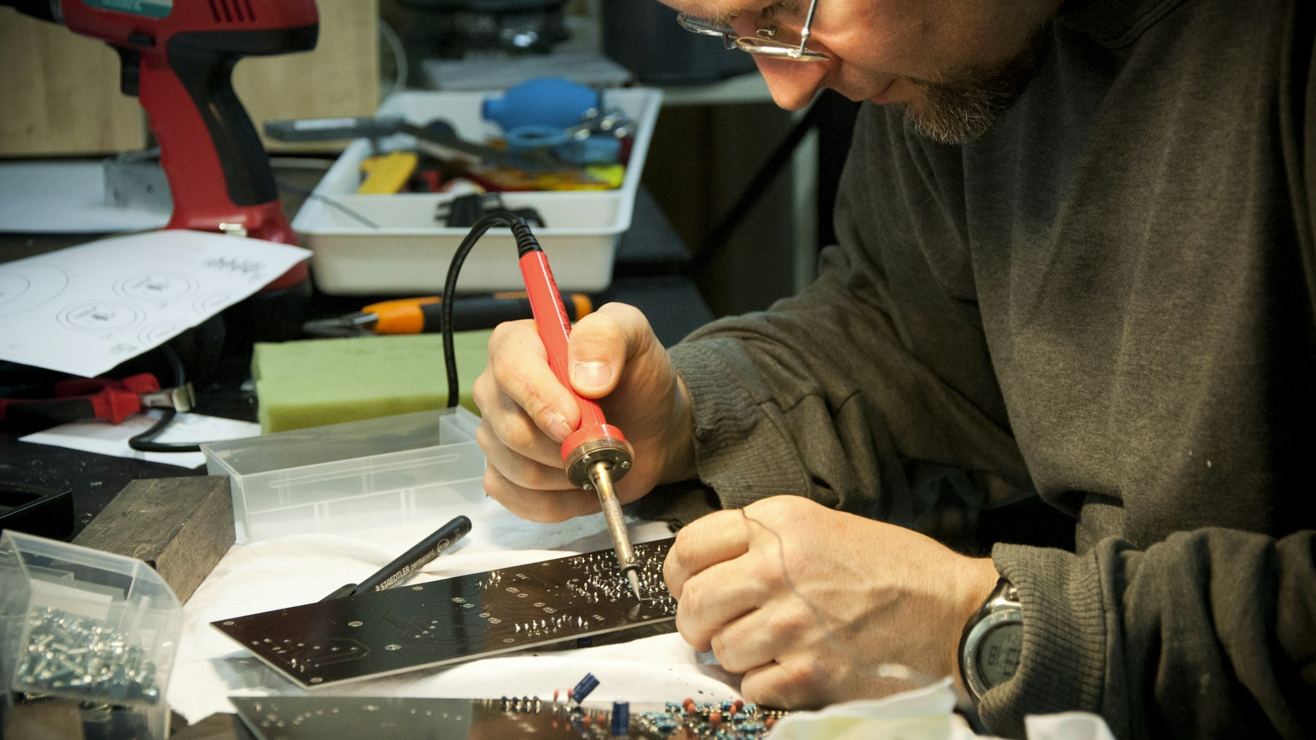 man fixing the device using soldering iron