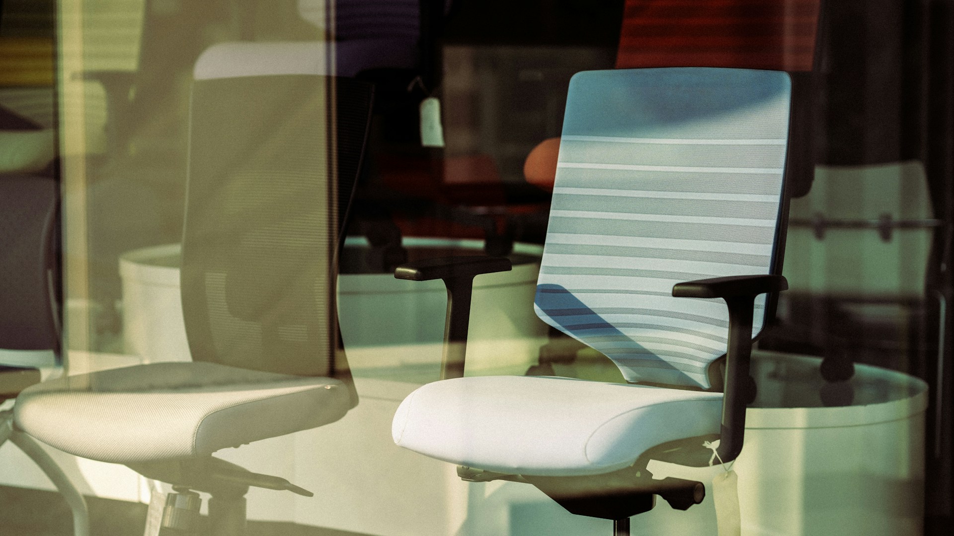 a white office chair sitting in front of a window